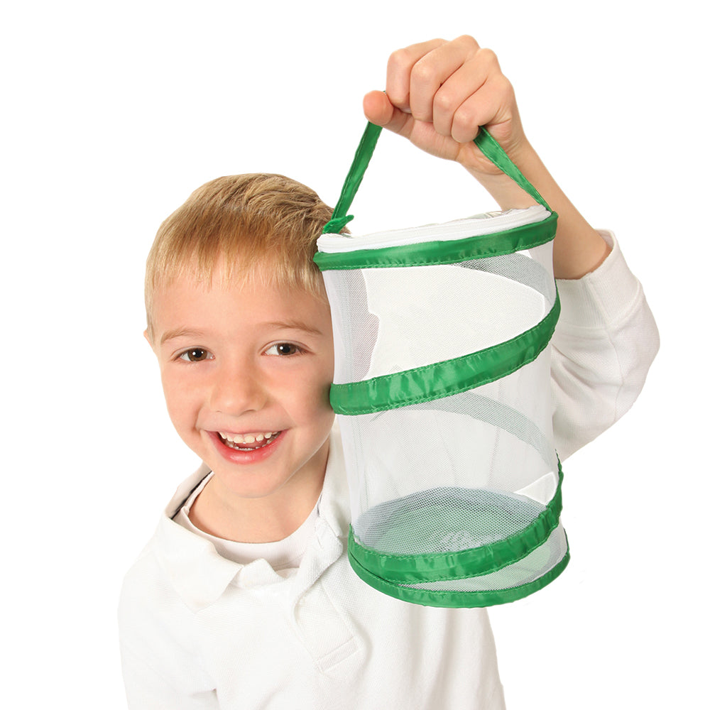 Young Boy holding the Pop Up Port a Bug Habitat. Mesh sides and nylon handle with a carry case which it can compress into. 